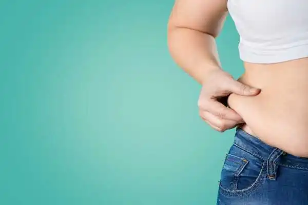 Image of woman pinching her love handles to show weight gain Caversham